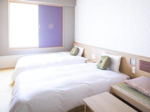 two beds in a small room with a window at Onyado Nono Kyoto Shichijo Natural Hot Spring in Kyoto