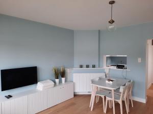a living room with a table and a tv at Lelies at westende in Westende