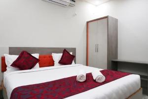 sypialnia z dużym białym łóżkiem z czerwonymi poduszkami w obiekcie Classio Residency w mieście Puducherry