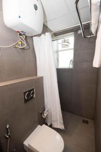 a small bathroom with a toilet and a window at Hotel Vemara in Panaji