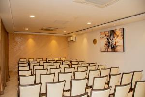 a conference room with chairs and a large screen at HOTEL AFRICANA LSK in Lusaka