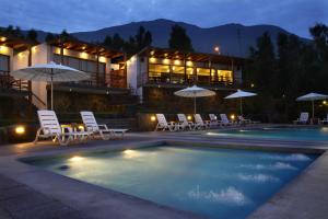a house with a swimming pool with chairs and umbrellas at El Molino Hotel y Restaurant in Lunahuaná