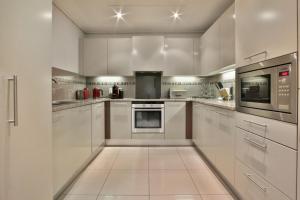 a large kitchen with white cabinets and appliances at Cape Royale 2 Bedroom Luxury Apartment with Views in Cape Town