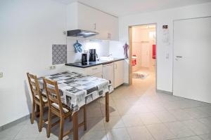 a kitchen with a table with chairs and a stove at Haus Ruther - Apartment in Bad Saulgau +10 photos