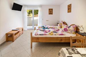 a bedroom with a bed and a desk and a television at Haus Ruther - Apartment in Bad Saulgau