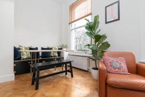 ein Wohnzimmer mit einem Sofa, einem Tisch und einem Stuhl in der Unterkunft GuestReady - Beautiful Flat on Newington Green in London