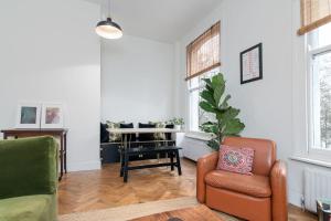 ein Wohnzimmer mit 2 Stühlen und einem Klavier in der Unterkunft GuestReady - Beautiful Flat on Newington Green in London