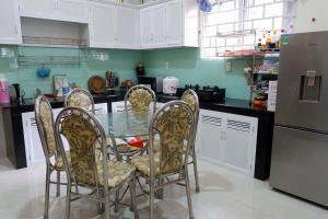 a kitchen with a glass table with chairs and a refrigerator at Tuan Vu Hai Dang Da Lat in Da Thanh