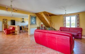 a living room with red furniture and a staircase at Maison confortable avec piscine à Villentrois-Faverolles 250m² in Faverolles