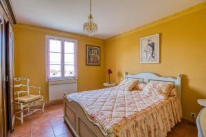 a bedroom with a bed and a chair and a window at Maison confortable avec piscine à Villentrois-Faverolles 250m² in Faverolles