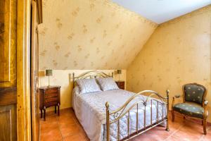 a bedroom with a bed and a chair at Maison confortable avec piscine à Villentrois-Faverolles 250m² in Faverolles