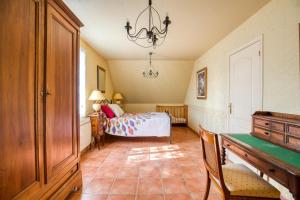 a bedroom with a bed and a table and a desk at Maison confortable avec piscine à Villentrois-Faverolles 250m² in Faverolles +12 photos