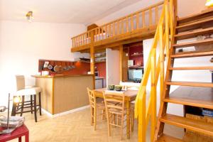 a kitchen and dining room with a loft bed and a table at Appartement charmant avec piscine à Porticcio - 32 m² in Porticcio +21 photos