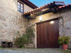 eine hölzerne Garagentür an der Seite eines Steingebäudes in der Unterkunft Comfortable Countryside House in Eira-Vedra with Shared Pool in Vieira do Minho