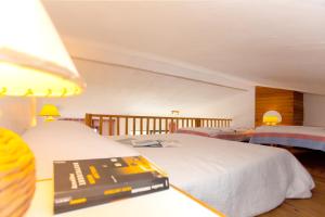 ポルティシオにあるAppartement de 2 chambres a Porticcio a 800 m de la plage avec piscine partagee balcon amenage et wifiのベッドルーム1室(ベッド2台、テーブル上の本付)