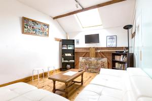 a living room with a white couch and a table at Maison de 4 chambres avec jardin amenage et wifi a Monthenault in Monthenault