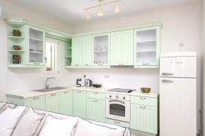 a kitchen with green cabinets and a white refrigerator at Spacious Villa in Naxos with Sea View in Naxos Chora