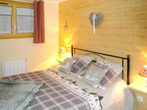 ein Schlafzimmer mit einem Bett und einer Holzwand in der Unterkunft Appartement de 2 chambres avec sauna jardin amenage et wifi a Xonrupt Longemer in Xonrupt-Longemer
