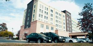 grupa samochodów zaparkowanych przed budynkiem w obiekcie Hotel Executive Suites w mieście Carteret