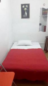 a red and white bed in a white room at Studio a Fort de France a 500 m de la plage avec balcon amenage et wifi in Fort-de-France