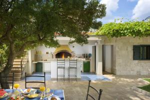 an outdoor kitchen with a table and chairs at Panoramic Villa in Prgomet, Sea View and Private Pool in Plano