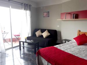 una camera con letto, divano e tavolo di Studio at Playa San Marcos 20 m away from the beach with sea view shared pool and furnished terrace a Icod de los Vinos
