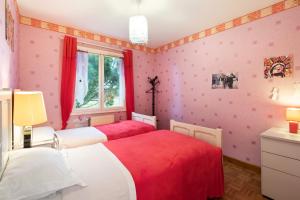 two beds in a room with pink walls at Maison chaleureuse Saint-Cyr-sur-le-Rhône in Saint-Cyr-sur-le-Rhône