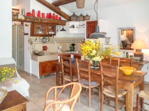 een keuken met een houten tafel en stoelen bij Maison de 2 chambres avec piscine partagee terrasse amenagee et wifi a Oppede in Oppède
