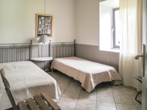 a room with two beds and a chair and a window at Maison charmante à Oppède avec piscine partagée in Oppède +14 photos