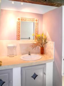 a bathroom with a sink and a mirror at Maison charmante à Oppède avec piscine partagée in Oppède