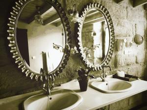 baño con 2 lavabos y espejo grande en La Casona de Calderón Gastronomic & Boutique Hotel en Osuna