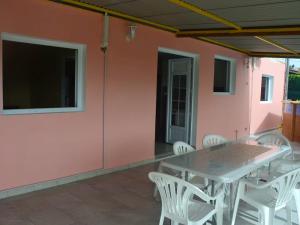 une table et des chaises sur une terrasse avec un mur rose dans l'établissement Appartement de 2 chambres avec piscine privee jardin clos et wifi a Riviere Pilote a 5 km de la plage, à Rivière-Pilote
