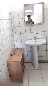 een persoon die een foto neemt van een badkamer met een wastafel bij Appartement charmant à Saint-Joseph avec jardin et terrasse, 60 m² in Saint-Joseph +7 foto's