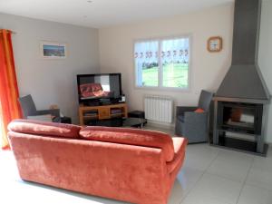 プルグレスカンにあるMaison accueillante avec vue sur la mer à Plougrescantのソファとテレビのあるリビングルーム