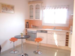 a kitchen with a sink and a table with stools at Maison de 4 chambres a Plougrescant a 400 m de la plage avec vue sur la mer jardin clos et wifi in Plougrescant