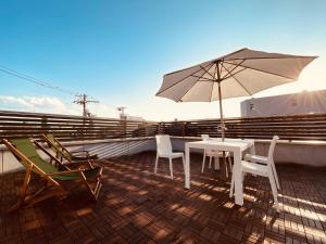 a patio with a table and chairs and an umbrella at Hostel Kay 101&102 in Osaka