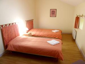 a bedroom with two beds with orange sheets at Maison de charme à Saint-Vincent-la-Châtre avec piscine partagée in Saint-Vincent-la-Châtre