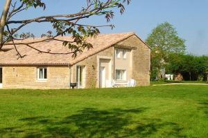 a brick house in a yard with a green lawn at Maison de 4 chambres avec piscine partagee jardin amenage et wifi a Saint Vincent la Chatre in Saint-Vincent-la-Châtre