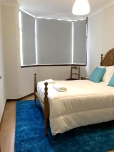 ヴィアナ・ド・カステロにある2 bedrooms appartement at Viana do Castelo 150 m away from the beach with sea view balcony and wifiのベッドルーム1室(大型ベッド1台、青い敷物付)