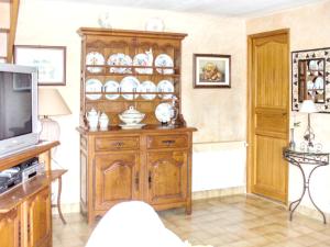 ein Wohnzimmer mit einer Holzhülle und einem TV in der Unterkunft Maison de 2 chambres avec jardin clos et wifi a Villeuneuve sur Yonne in Beaujard