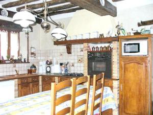 eine Küche mit Holzschränken und einem Tisch mit Stühlen in der Unterkunft Maison de 2 chambres avec jardin clos et wifi a Villeuneuve sur Yonne in Beaujard