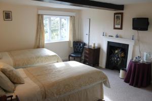 a hotel room with two beds and a fireplace at Ingon Bank Farm Bed And Breakfast in Stratford-upon-Avon