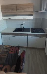 a persons feet in a kitchen with a sink and a counter at Studio Elisa in Caransebeş