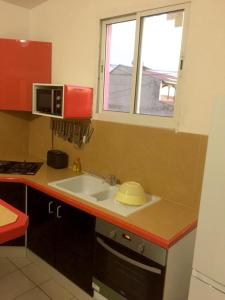 a kitchen with a sink and a microwave at Appartement de 2 chambres avec balcon et wifi a Pointe Noire a 4 km de la plage in Pointe-Noire