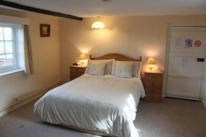 een slaapkamer met een bed met 2 nachtkastjes en 2 lampen bij Ingon Bank Farm Bed And Breakfast in Stratford-upon-Avon