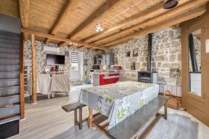 a kitchen with a table and a stone wall at Maison charmante à Valprivas avec jardin privé. in Valprivas