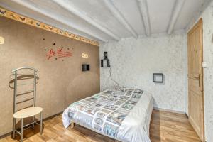 a bedroom with a bed and a ladder and a chair at Maison charmante à Valprivas avec jardin privé. in Valprivas