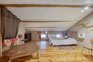 a bedroom with a bed and a wooden floor at Maison charmante à Valprivas avec jardin privé. in Valprivas