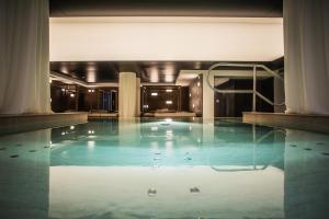 uma grande piscina com água azul num edifício em Hotel San Giacomo Spa&Gourmet em Brentonico