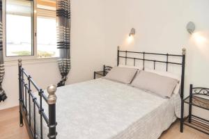 a bedroom with a black bed and a window at Appartement spacieux à Port-de-Bouc avec piscine et vue mer in Port-de-Bouc +25 photos